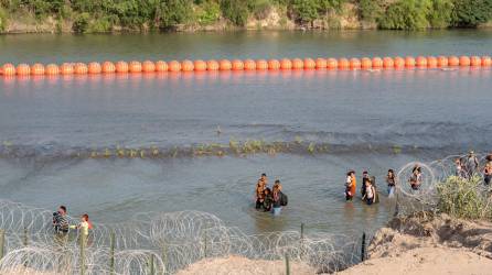 Migrantes cruzan el río bravo pese a una barrera de boyas instaladas por el Gobierno de Texas.