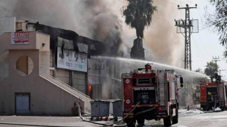 Los camiones de bomberos israelíes apagan una fábrica en llamas en la ciudad de Sderot, en el sur de Israel, después de que, según los informes, fue alcanzada por cohetes disparados desde la Franja de Gaza el 12 de noviembre de 2019. El ejército de Israel mató a un comandante del grupo militante palestino Jihad Islámica en un ataque contra su casa. en Gaza temprano en la mañana, lo que provocó represalias de bombardeos desde la Franja de Gaza hacia Israel, donde los residentes corrieron a bombardear refugios mientras sonaban sirenas de ataque aéreo en varias partes del país. / AFP / Ahmad GHARABLI