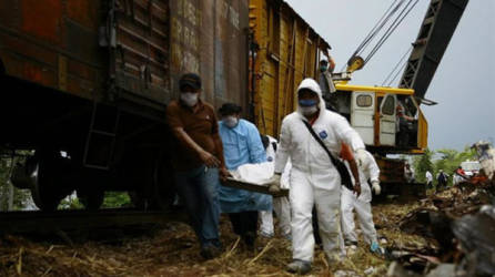 Personal de Protección Civil carga hoy, jueves 29 de agosto de 2013, un cuerpo más de la zona de escombros donde el tren 'La Bestia' se descarriló el fin de semana pasado en el tramo de Tembladeras, del municipio de Huimanguillo (México) y en el que se transportaban centenares de indocumentados centroamericanos por lo que la cifra de fallecidos ascendería a doce. EFE