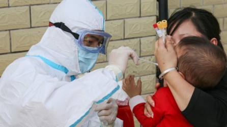 Personal médico le hace la prueba del coronavirus a un niño. Foto:AFP/Referencia