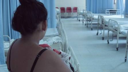 'María' carga en sus brazos a su bebé en la sala maternidad del hospital Leonardo Martínez.