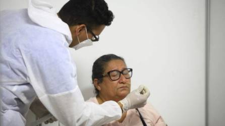 Un microbiólogo hace un hisopado a una paciente en el triaje de Expocentro. Foto: Moisés Valenzuela.