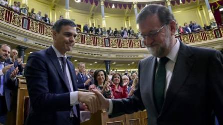 El nuevo primer ministro de España, Pedro Sánchez (L), estrecha la mano del primer ministro de España, Mariano Rajoy (R), tras una votación sobre una moción de censura en la Cámara Baja del Parlamento español en Madrid.
