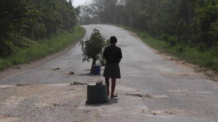 En la frontera departamental entre Santa Bárbara y Copán, en las comunidades de Callejones y Chiquila, enormes hoyos en la carretera son usados por las personas para pedir dinero. Fotos: Melvin Cubas