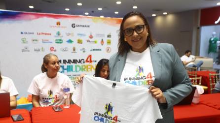 Una sampedrana muestra la camiseta oficinal de Running for The Children.
