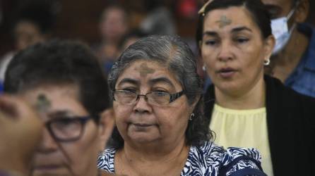 Personas con una cruz de ceniza en la frente como parte de la celebración de la Cuaresma.