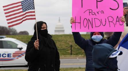 Decenas de hondureños sostienen pancartas y banderas estadounidenses mientras marchan dirección a la Casa Blanca en Washington (EE.UU.), en una fotografía de archivo. EFE/Lenin Nolly