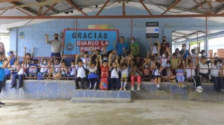 Docentes y alumnos levantan las manos en el escenario del centro, el cual tiene cerámica nueva. Fotos: Moisés Valenzuela