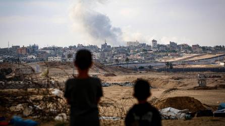 Los niños observan el humo que se eleva durante los ataques israelíes al este de Rafah, en el sur de la Franja de Gaza, el 13 de mayo de 2024, en medio del conflicto en curso entre Israel y el grupo militante palestino Hamás.