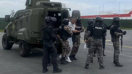 El exvicepresidente ecuatoriano Jorge Glas (C) siendo escoltado por miembros de la policía antes de su traslado a la prisión de máxima seguridad La Roca en Guayaquil, Ecuador.