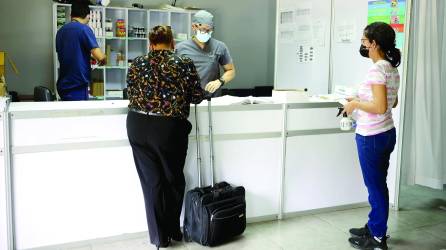 Dos pacientes esperan por medicinas en el triaje del Infop, donde están recibiendo de ocho a 10 consultas diarias.