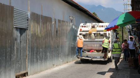 El carro recolector de basura recolecta residuos sólidos en el centro de Gracias, Lempira
