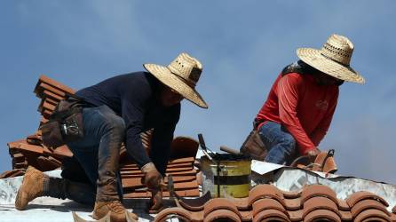 Dos personas trabajan en el techo de una Iglesia en Arizona.