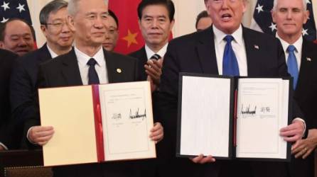 El funcionario chino, Liu He, y Trump muestran el acuerdo comercial firmado entre China y EEUU para poner fin a la guerra comercial entre las potencias económicas./AFP.