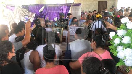 Amigos y familiares ubicados alrededor de los ataúdes en Olanchito.