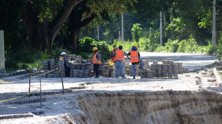 Obreros trabajan en la construcción del puente sobre el río Santa Ana.