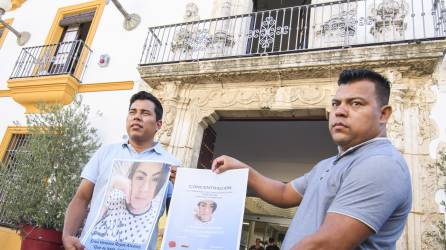 Los representantes de la Asociación Nicaragüense de Sevilla, José Daniel Rodríguez(i) y su fundador, Luis Rodríguez, muestran fotos de Erica Vanessa Reyes Álvarez, la joven nicaragüense de 22 años asesinada.