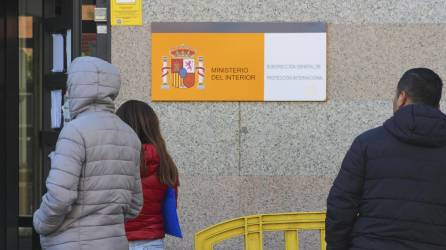 Una oficina para solicitantes de asilo en Madrid ante la que esperan inmigrantes latinoamericanos. EFE/Luis Ángel Reglero
