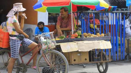 Un señor vende frutas en la acera del centro del municipio de La Lima, Cortés.
