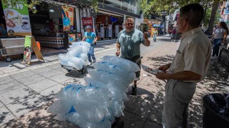 Trabajadores transportan bolsas de hielo en la ciudad de Monterrey (México).