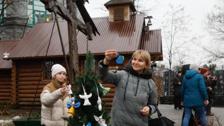 Los ucranianos decoran un árbol de Navidad cerca de la Plaza de la Independencia en Kiev, Ucrania. Ángeles y corazones simbolizan las almas de las personas asesinadas durante el levantamiento de Maidan en 2013-2014 y el conflicto armado entre Rusia y Ucrania que comenzó en febrero de 2022. EFE/EPA/SERGEY DOLZHENKO
