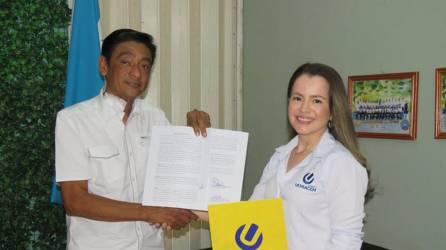 Elsy Morales, directora de RSE de Cemento Ultracem y el director del centro básico Antonio C. Rivera firman el convenio de colaboración.