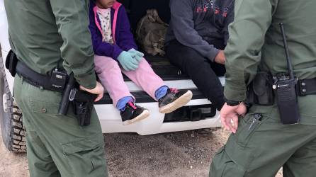 Fotografía de archivo donde aparecen dos agentes de la Patrulla Fronteriza mientras atienden a unos niños en un punto del área conocido como Quitobaquito, en la frontera de Arizona con México (EE.UU.)