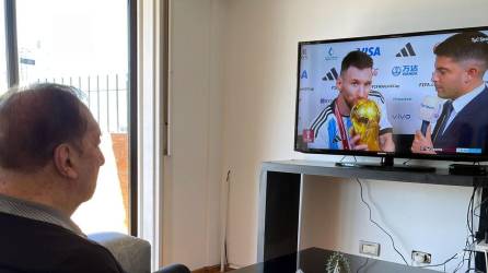 Carlos Salvador Bilardo observando en la televisión a Messi besando la Copa del Mundo.