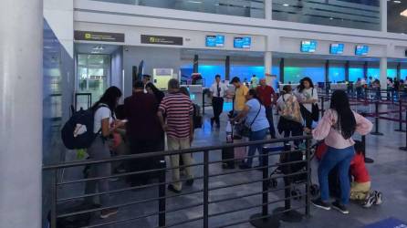 Viajeros hacen fila en el aeropuerto Ramón Villeda Morales de San Pedro Sula.