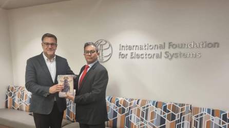 Máximo Zaldívar, de la Fundación Internacional de Sistemas Electorales, recibe de Javier Franco una copia de su libro “No solo fake news”.