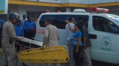 Momentos en que miembros de los bomberos trasladaban a los dos supuestos delincuentes.