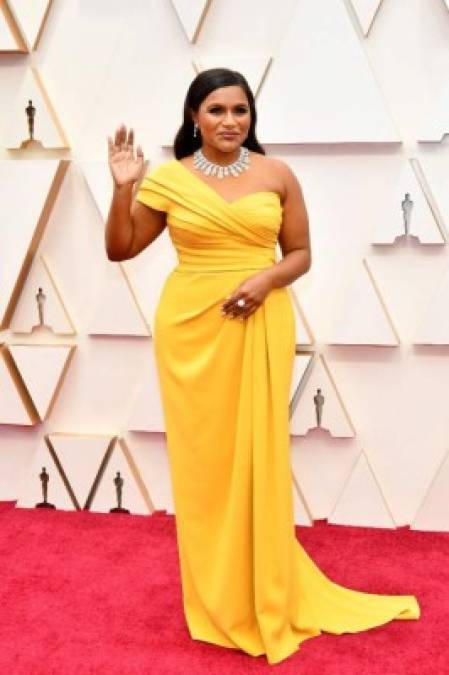 La actriz Mindy Kaling con un vestido amarillo sobre la alfombra roja de los Premios Óscar 2020.