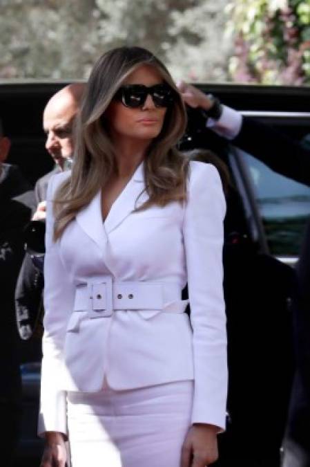 Melania lució impecable con un traje blanco entallado y un cinturón del mismo color. Complementó su look con lentes oscuros y stilettos rojo y blanco.