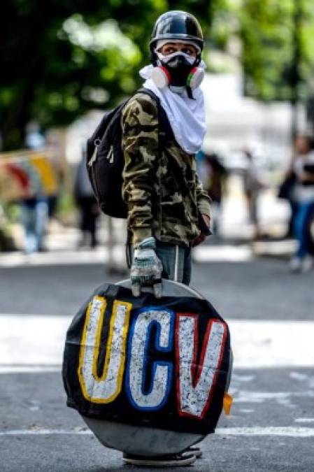 An opposition activist blocks the access to the Central University of Venezuela during a demonstration against the government of Venezuelan President Nicolas Maduro, in Caracas on June 26, 2017. <br/>A political and economic crisis in the oil-producing country has spawned often violent demonstrations by protesters demanding Maduro's resignation and new elections. The unrest has left 75 people dead since April 1. / AFP PHOTO / FEDERICO PARRA