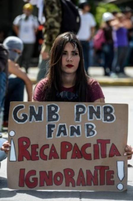 An opposition activist blocks access to the Central University of Venezuela during a demonstration against the government of Venezuelan President Nicolas Maduro, in Caracas on June 26, 2017. <br/>A political and economic crisis in the oil-producing country has spawned often violent demonstrations by protesters demanding Maduro's resignation and new elections. The unrest has left 75 people dead since April 1. / AFP PHOTO / FEDERICO PARRA