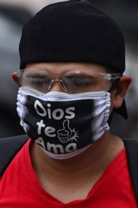 A man wears a face mask reading 'God loves you' amid the new coronavirus pandemic in Tegucigalpa on June 17, 2020. - Honduras has so far registered 9,658 contagions and 478 deaths from COVID-19. (Photo by ORLANDO SIERRA / AFP)