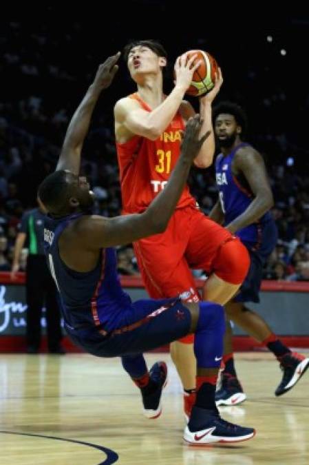 BALONCESTO. Cuidado, Green. Draymond Green de Estados Unidos cae ante Wang Zhelin, quien avanza hacia la canasta durante el amistoso en el Staples Center de Los Ángeles.