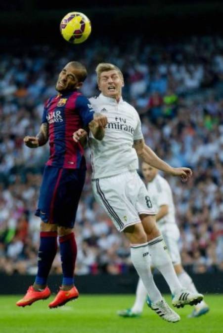 Dani Alves y Toni Kroos saltan por el balón.