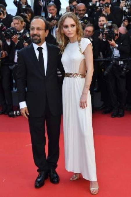 French-US actress and model Lily-Rose Depp (R) and Iranian director Asghar Farhadi pose as they arrive on May 17, 2017 for the screening of the film 'Ismael's Ghosts' (Les Fantomes d'Ismael) during the opening ceremony of the 70th edition of the Cannes Film Festival in Cannes, southern France. / AFP PHOTO / Alberto PIZZOLI