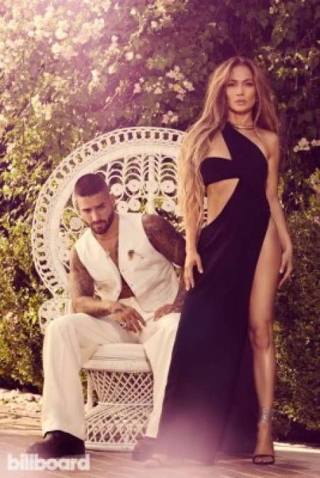 En esta imagen, se puede apreciar a una hermosa JLo parada frente a Maluma y luciendo un sensual vestido negro con una gran abertura que deja ver sus bien formadas piernas.