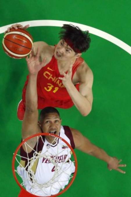 BALONCESTO. En plena lucha. Wang Zhelin (arriba) disputa el rebote con Miguel Marriaga en el partido de baloncesto entre Venezuela y China. Foto: AFP/Jim Young