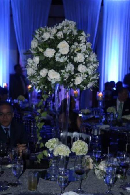 Los hermosos arreglos florales de rosas blancas decoraron las mesas de la boda. Las sillas tiffany en tono plata no faltaron.