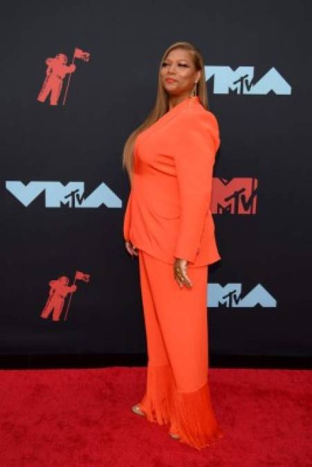 La actriz Queen Latifah llegó con un traje color naranja.