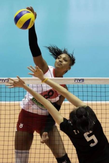 Maguilaura Frias (a), de Perú, clava la bola contra Pleumjit Thinkaow, de Tailandia, en un partido de voleibol femenino entre ambos países.