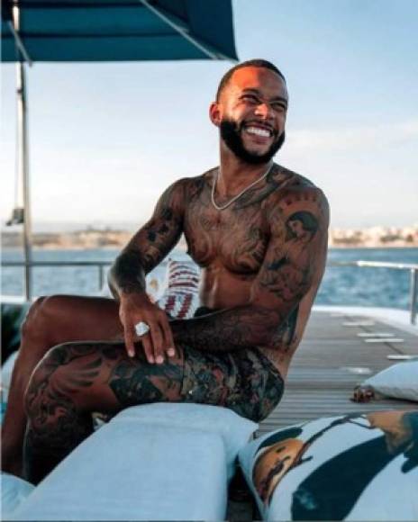 Memphis Depay, delantero del Lyon, luce sus tatuajes en un barco.