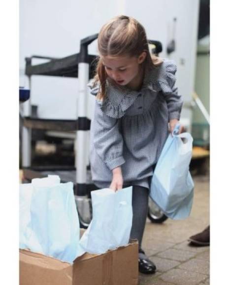 Las imágenes, tomadas por su madre, la duquesa de Cambridge, muestran a Charlotte entregando paquetes de alimentos a personas mayores durante la pandemia de coronavirus a finales de abril.