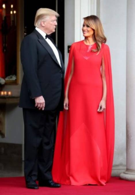 Melania se decantó por un espectacular vestido rojo con capa de Givenchy, la casa de moda que firmó el vestido de novia de Meghan Markle, esposa del príncipe Harry.