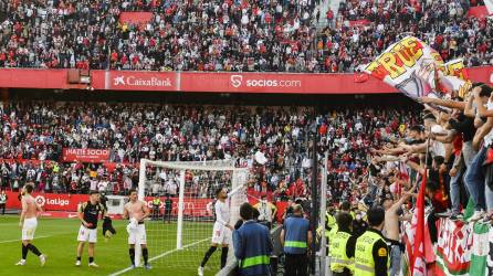 Los jugadores del Sevilla celebran con los aficionados sevillistas su triunfo ante el Betis al final del encuentro correspondiente a la jornada 26 de primera división disputado en el estadio Ramón Sánchez Pizjúan de Sevilla.