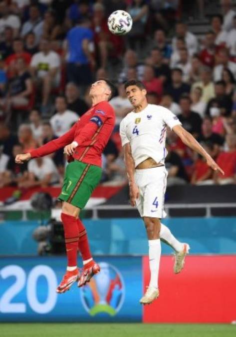 Cristiano Ronaldo saltando por el balón con Raphael Varane, su excompañero en el Real Madrid.