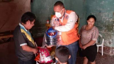 Un funcionario del sistema de emeregencias guatemalteco (Conred), entrega víveres a una familia afectada por las lluvias en el departamento de Jutiapa.